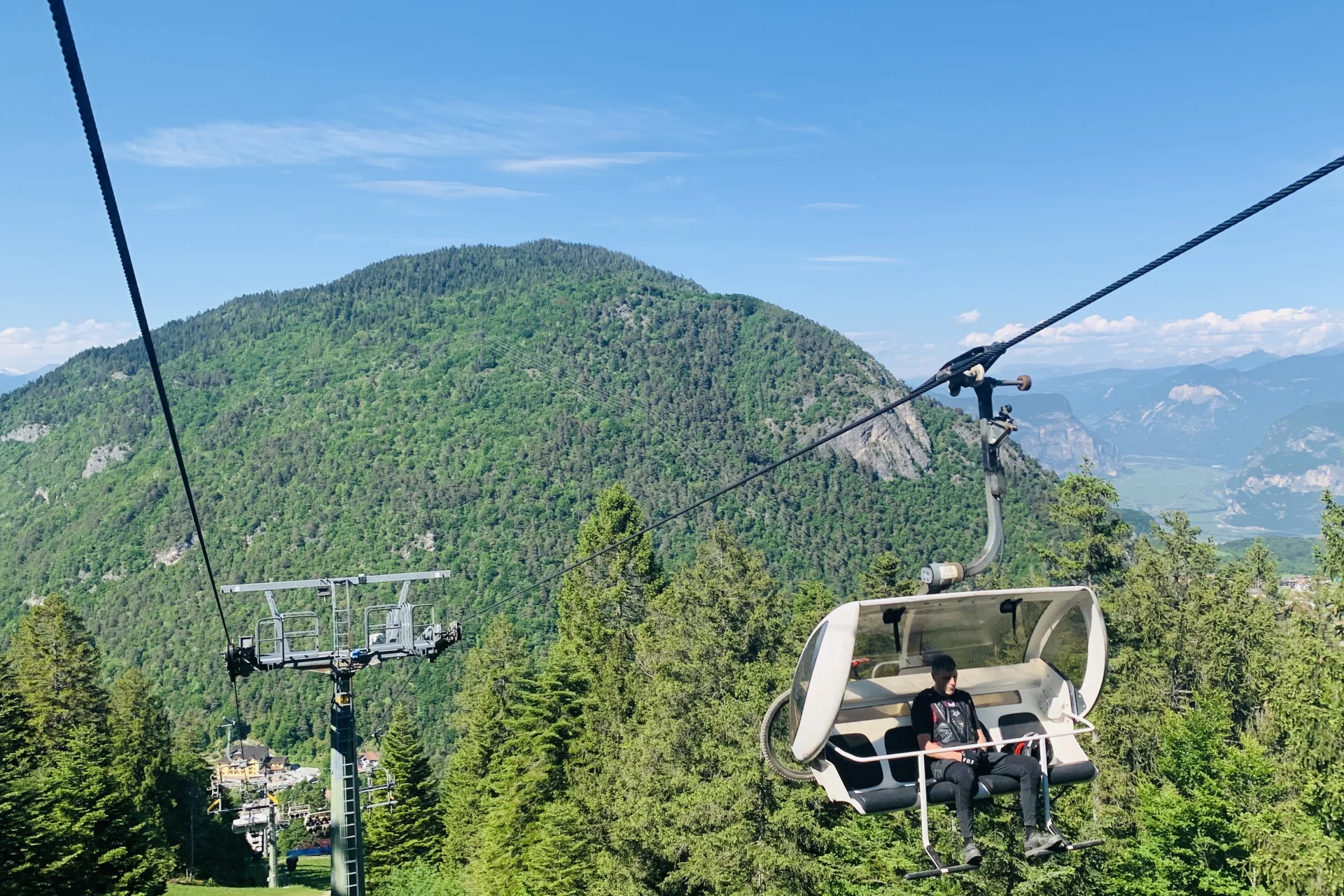 Chairlift at Paganella bike park taking cyclists and their bikes up the mountain.