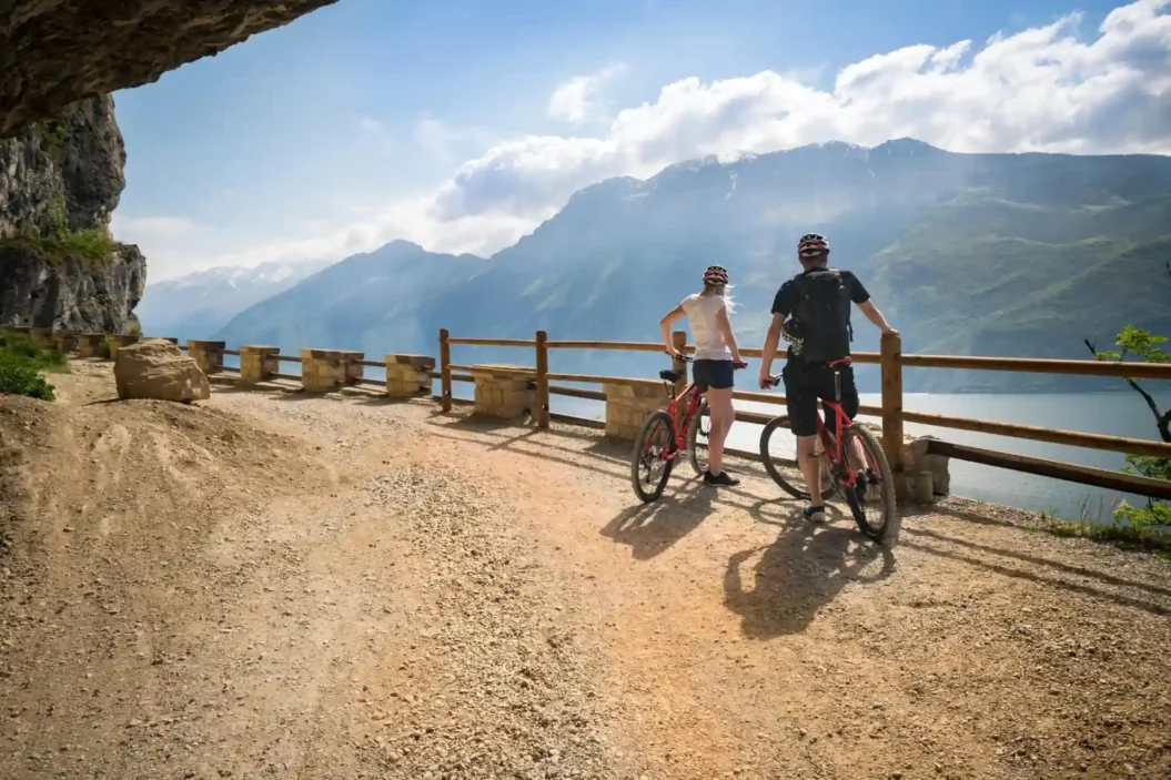 Cyclist looking at view of Lake Garda along the Ponale trail - Riva del Garda.